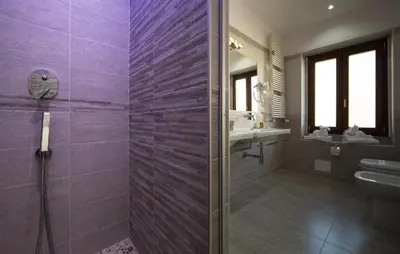 a purple bathroom with a shower and a sink at Love of Rome in Rome