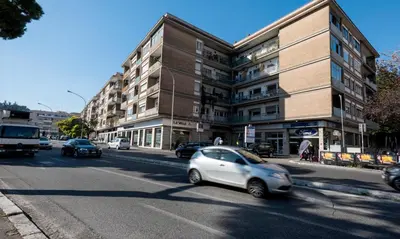 a white car driving down a street in front of a building at Love of Rome in Rome