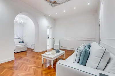 a white living room with a white couch and a table at New opening Spagna Suite in Rome