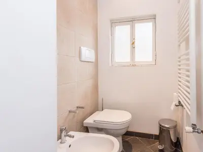 a bathroom with a toilet and a sink and a window at Spacious 2BR in the historic center in Rome