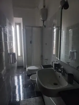 a bathroom with two toilets and a sink and a mirror at tommy's house in Rome