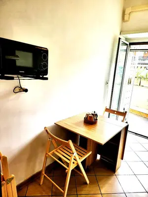 a room with a wooden table and a tv on the wall at Da Zia Elena in Rome