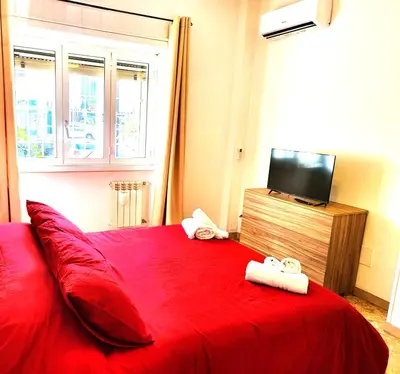 a bedroom with a red bed with two towels on it at Da Zia Elena in Rome