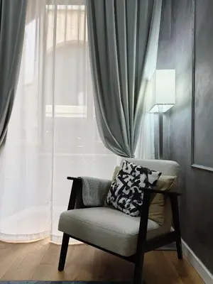 a chair with a pillow sitting in front of a window at Roma center home in Rome