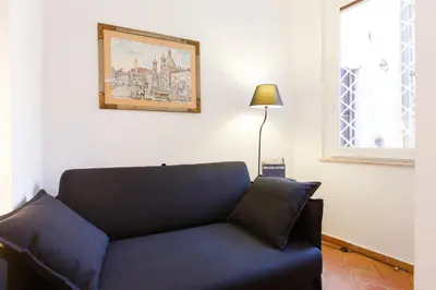 a blue couch in a room with a picture on the wall at NAVONA, Old Rome Lodge in Rome