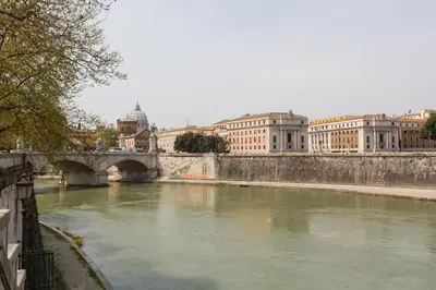 a bridge over a river in a city with buildings at NAVONA, Old Rome Lodge in Rome