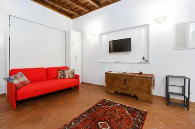 a living room with a red couch and a tv at NAVONA, Old Rome Lodge in Rome