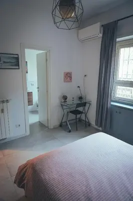 a bedroom with a bed and a table and a window at Urban House Monteverde in Rome