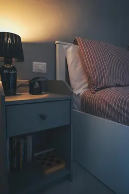 a bed with a night stand with a lamp on it at Urban House Monteverde in Rome