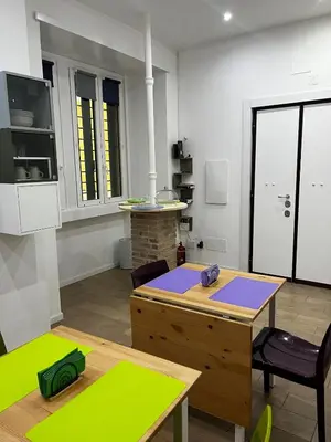 a room with a table and chairs and a kitchen at DomuSolina in Rome