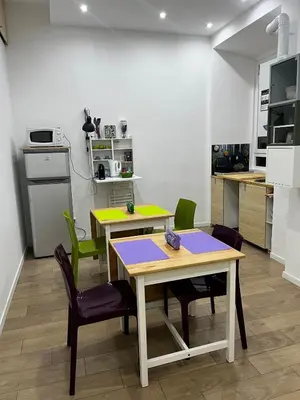 a kitchen with two tables and green chairs at DomuSolina in Rome