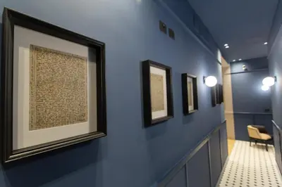 a hallway with several framed pictures on the wall at Saint Suites in Rome
