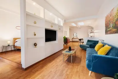 a living room with a blue couch and a tv at Lungotevere Trastevere Loft in Rome
