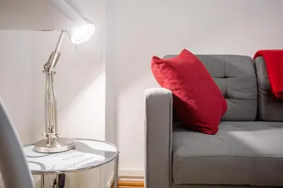 a red pillow sitting on a couch with a lamp at Casina Soleggiata in Rome