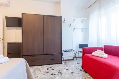 a bedroom with a large cabinet and a red chair at Casina Soleggiata in Rome