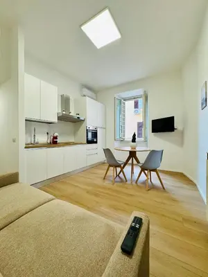 a room with a bed and a table and a kitchen at Vaschome in Rome