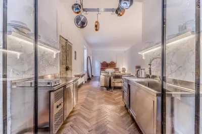 a kitchen with stainless steel appliances and wooden floors at EVA Loft in Rome