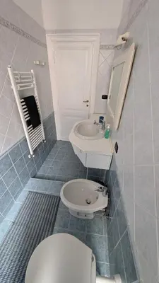 a white bathroom with a toilet and a sink at Eleganza e stile Capitolino in Rome