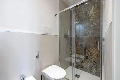 a bathroom with a toilet and a glass shower at Belli San Giovanni Guest House in Rome