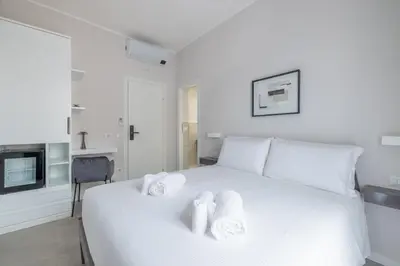 a bedroom with a white bed with towels on it at Belli San Giovanni Guest House in Rome