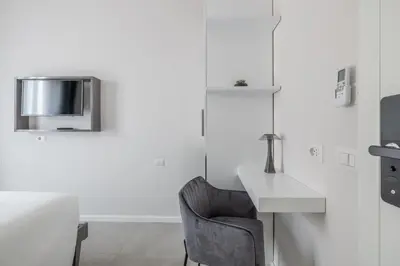 a white room with a desk and a chair at Belli San Giovanni Guest House in Rome