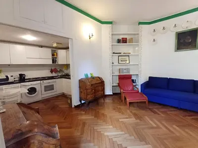 a living room with a blue couch and a kitchen at la casa del Duca a Monti in Rome