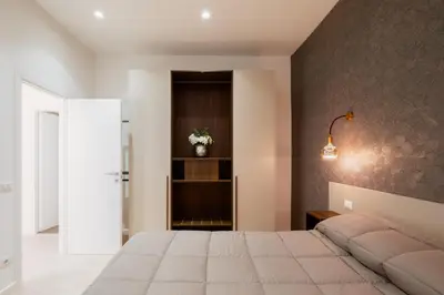 a bedroom with a large bed and a black wall at Giulio Cesare Flat - VATICAN in Rome