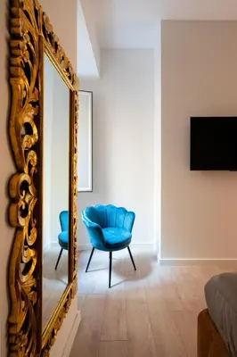 a room with a mirror and a blue chair at Giulio Cesare Flat - VATICAN in Rome