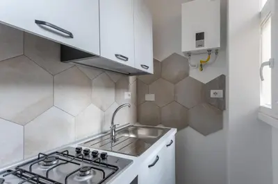 a kitchen with a sink and a stove at Skylife Modern 4-Bedroom Trastevere Apartment in Rome