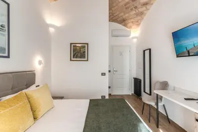 a living room with a bed and a desk at Rose Inn Guest House in Rome