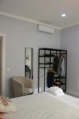 a bedroom with a bed with a chair and a closet at Alicemaria Vatican Comfortable Apartment in Rome