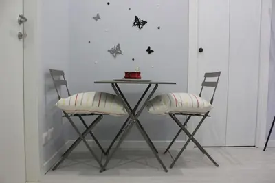 a table with two chairs and a table with a cake on it at Alicemaria Vatican Comfortable Apartment in Rome