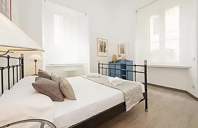 two beds in a bedroom with white walls at Ungaretti Vatican Apartment in Rome