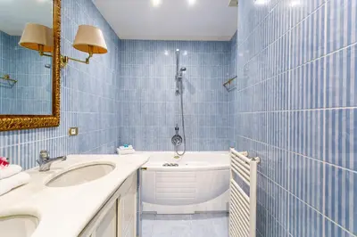 a blue tiled bathroom with a sink and a tub at iFlat Classy & Spacious apt near Campo de Fiori in Rome