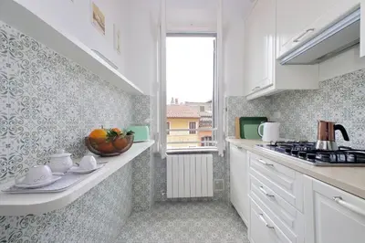 a kitchen with white cabinets and a sink and a window at Montevecchio2 in Rome