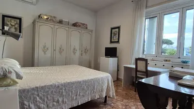 a bedroom with a bed and a table and a desk at Soggiorni Romani in Rome