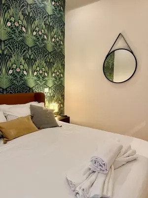 a bedroom with a bed with a mirror on the wall at Monti Cozy Apartment in Rome