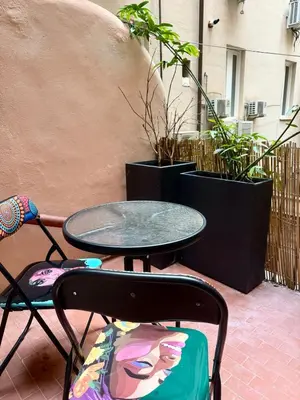 a table and a chair and a table and some plants at Monti Cozy Apartment in Rome