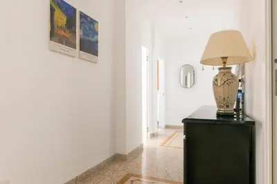 a lamp on top of a black dresser in a hallway at Family Rooms in Rome