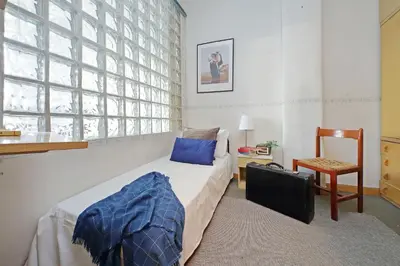 a bedroom with a bed and a chair and a window at Casa Giannetta in Rome