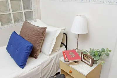 a room with a bed with pillows and a table with a lamp at Casa Giannetta in Rome