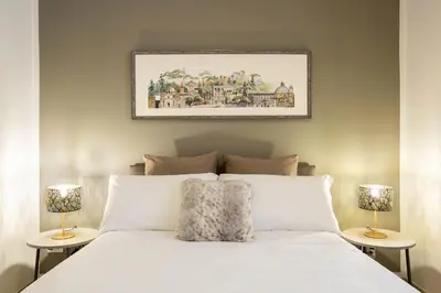 a bedroom with a white bed with two lamps at Residenza Gradinata al Vaticano in Rome