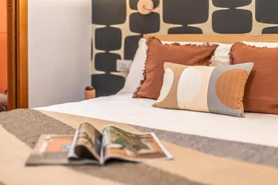 a bed with a book and a magazine on it at Giardino Privato & Comfort - Oasi di Relax a Roma in Rome