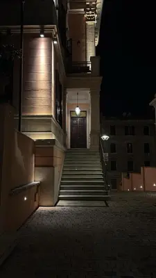 a building with stairs leading to a door at night at Amalia Vatican House in Rome