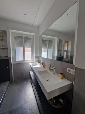 a bathroom with two sinks and a large mirror at Domus Roma Apartment in Rome