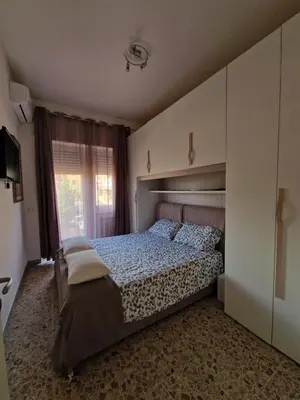 a bedroom with a large bed and a window at Domus Roma Apartment in Rome