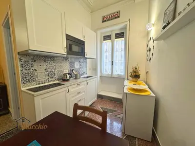 a kitchen with white cabinets and a table and a sink at Satrico43 - San Giovanni Stay in Rome