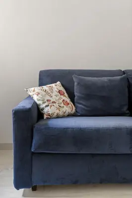 a blue couch with a pillow on it at Visconti58 Boutique House - Modern apt with balcony in Rome