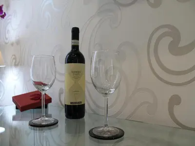 a bottle of wine and two wine glasses on a table at Elenoire Rooms & Suite in Rome