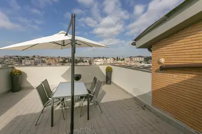 a table and chairs with an umbrella on a balcony at Terrazza San Pietro vicino metro A in Rome